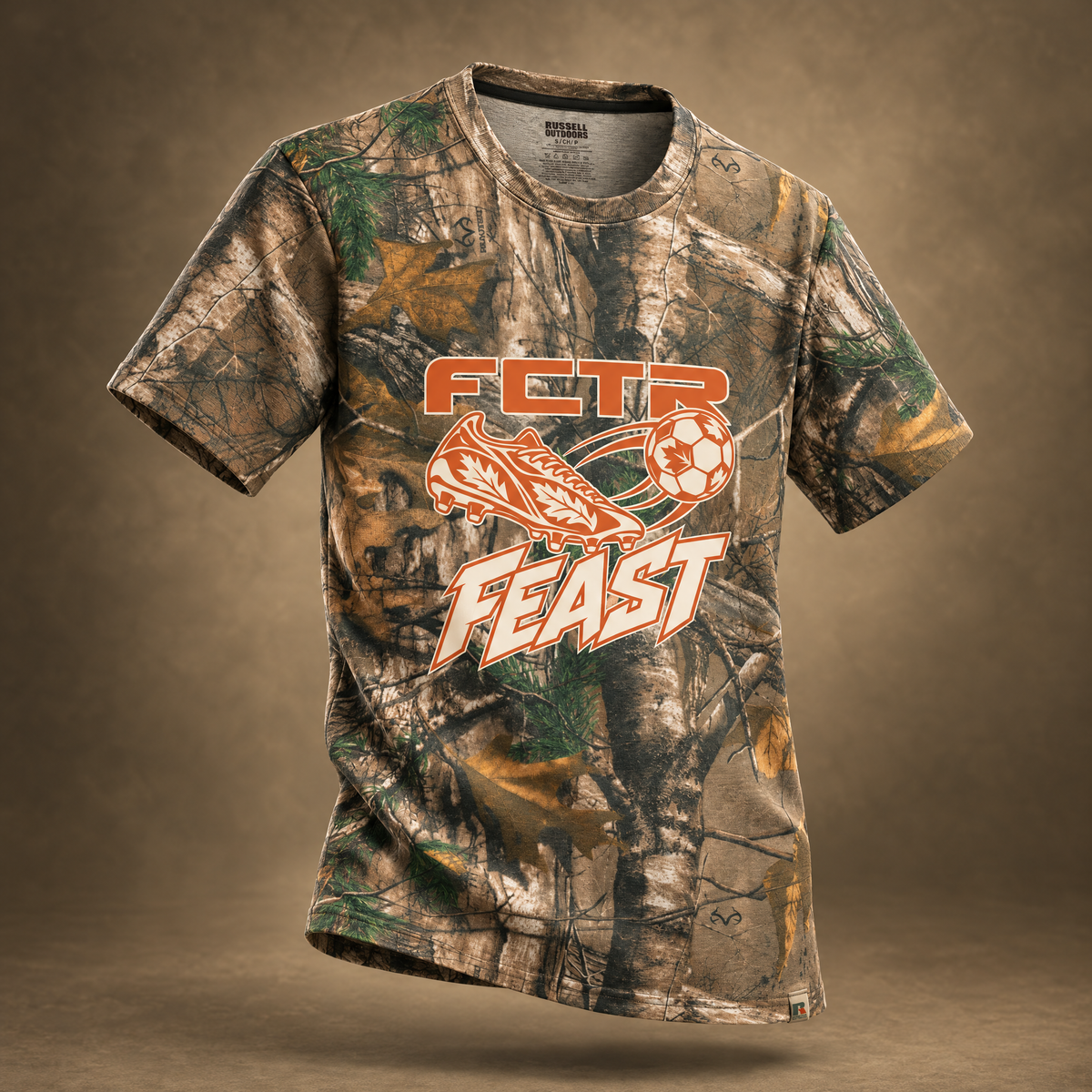 Adult Autumn Kick realtree camo t-shirt in Realtree Xtra with an orange FCTR Feast soccer cleat and ball graphic, front view.
